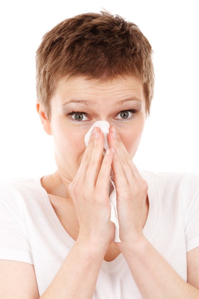 Woman Blowing Her Nose With a Tissue